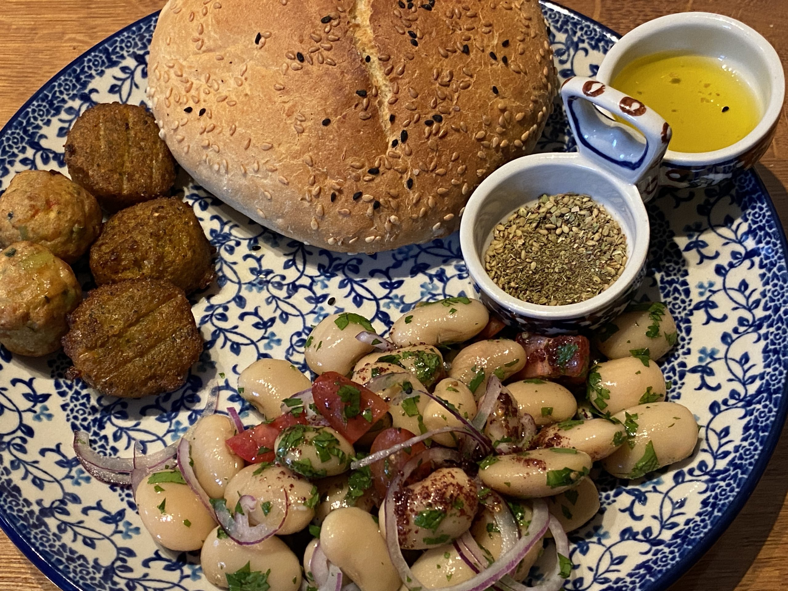 Bord met Turkse bonensalade, brood, falafel en sumak dressing