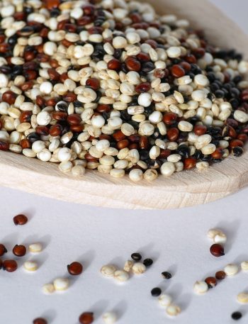 Lepel gevuld met ongekookte quinoa in drie kleuren
