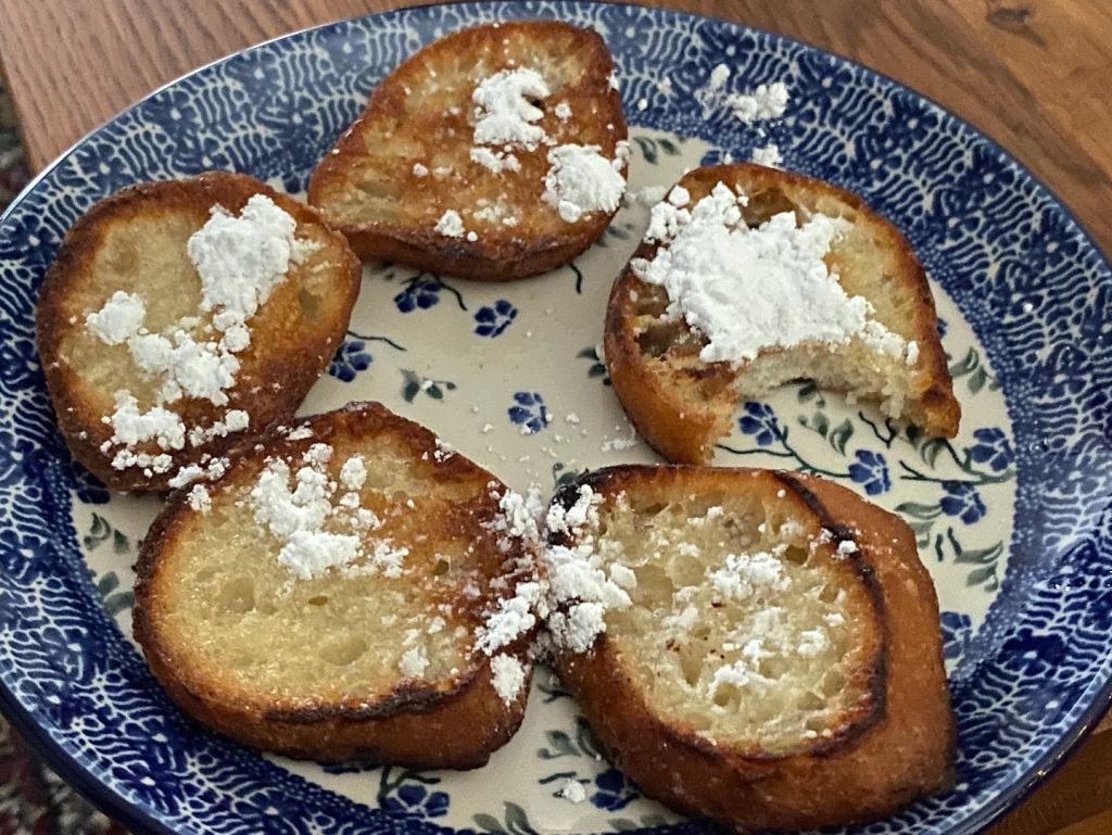 Plakjes oliebollen met poedersuiker