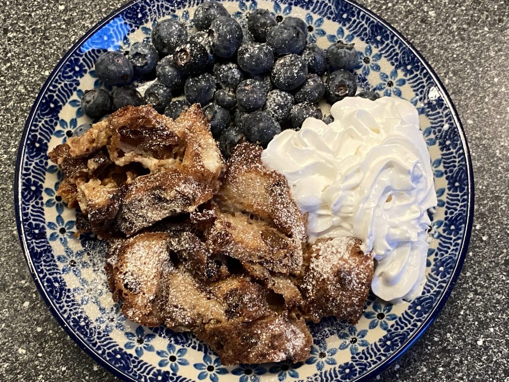 oliebollenpudding met blauwe bessen en slagroom