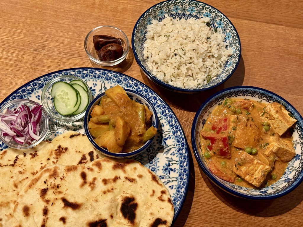 Borden en schaaltjes met Indiaas eten, waaronder tawa tofu, naan, komijnrijst